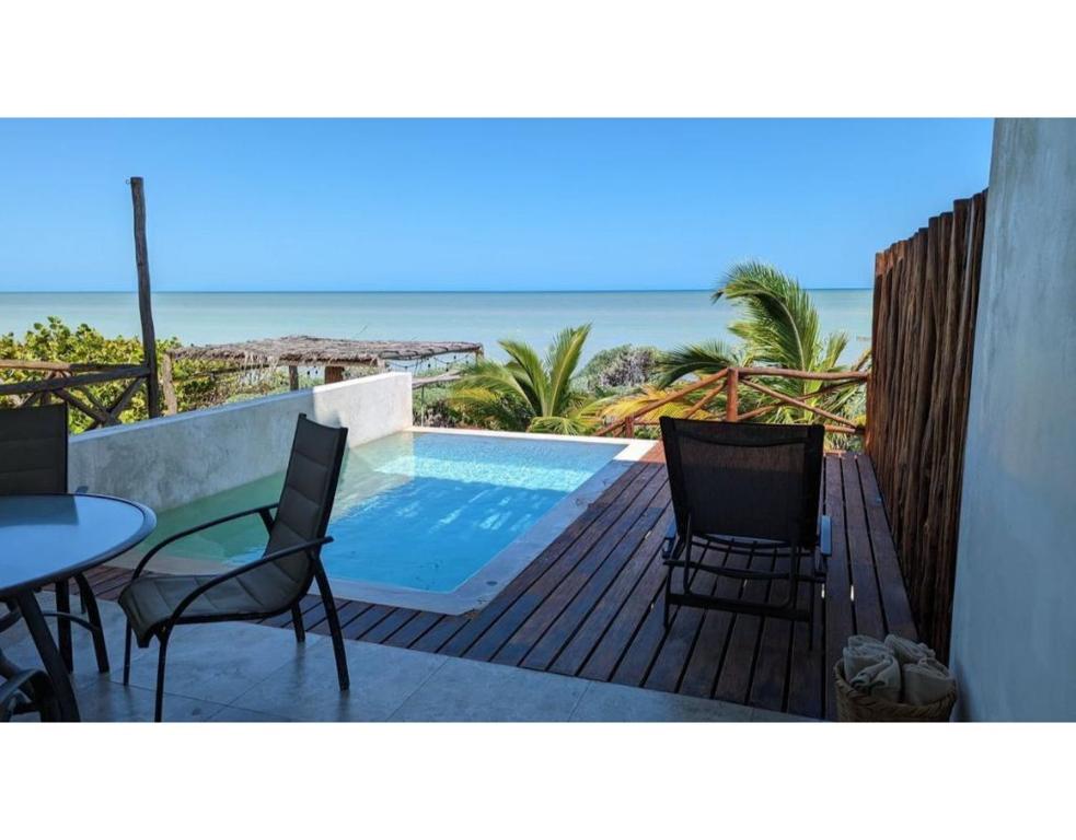 un balcon avec une table et des chaises et une piscine dans l'établissement Villa Caracol - Hello Progreso, à San Benito