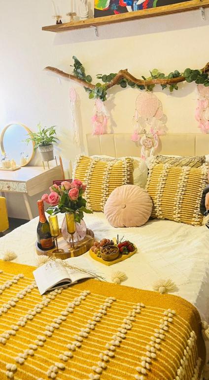 a bed with yellow pillows and food on it at Boho chic, fresh, modern apartment in Ixtapa