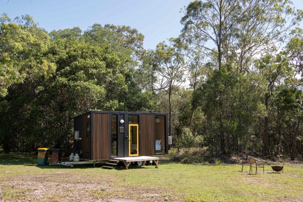 a tiny house in a field with a picnic table at Bush by the Bay by Tiny Away in River Heads