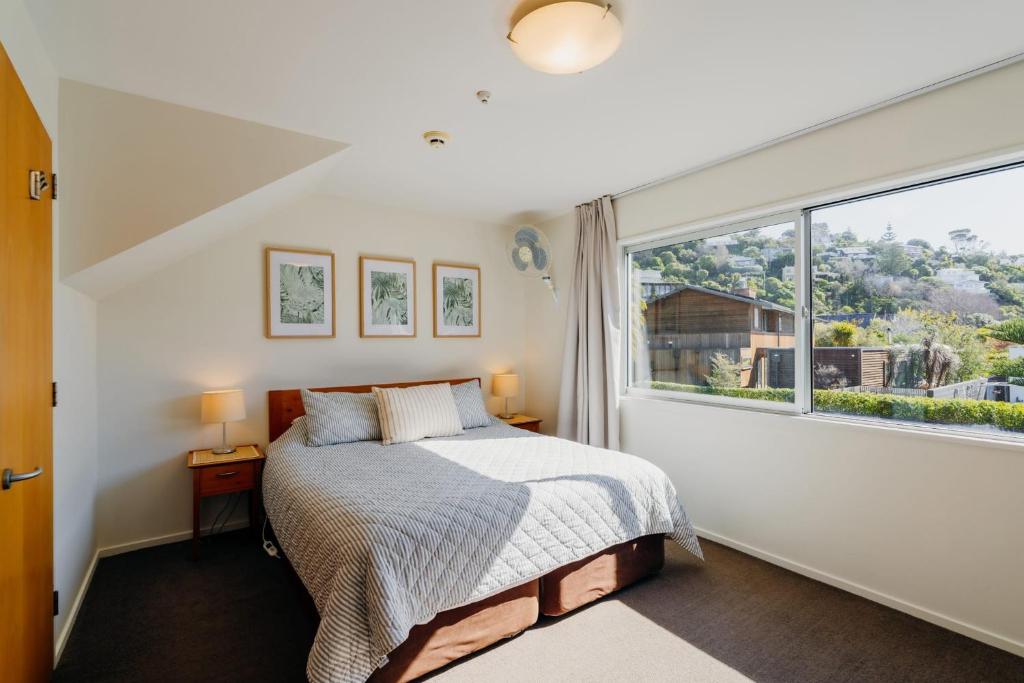 Un dormitorio con una cama y una ventana grande en Sumner Bay Motel, en Christchurch
