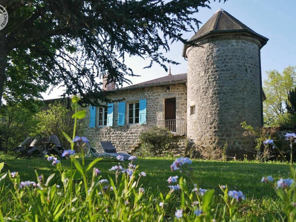 a brick house with a tower in the yard at Gîte de caractère du XIIIe siècle avec cheminée et Wi-Fi - FR-1-496-55 in Marlhes