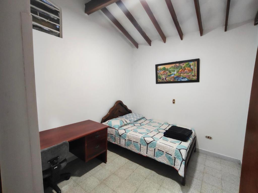 a bedroom with a desk and a bed and a piano at Kumho in Medellín