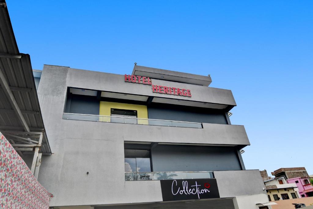 un palazzo grigio alto con un cartello sopra di Collection O Heritage a Indore