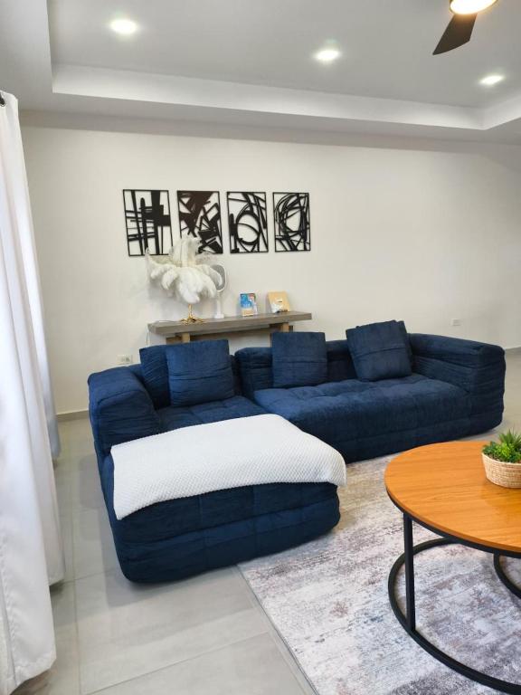 KoolbaaiSpacious 3BR Home with Own Private Cozy Pool的客厅里的一张蓝色沙发和一张桌子