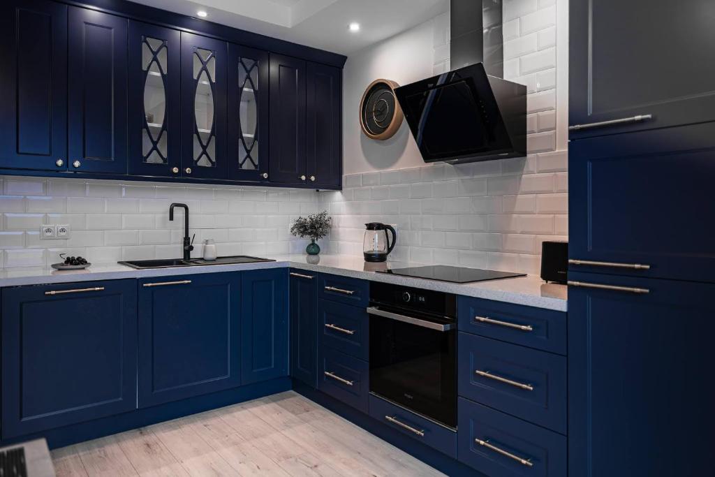 a kitchen with blue cabinets and a sink at LuxCity Apartment in the Center of Nowy Targ, FREE PARKING in Nowy Targ