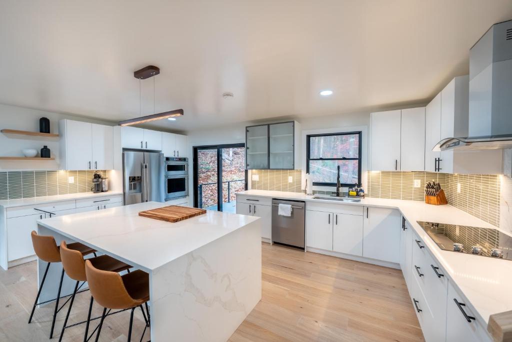 a kitchen with white cabinets and a large white island at Modern Entire Home Near UVA in Charlottesville