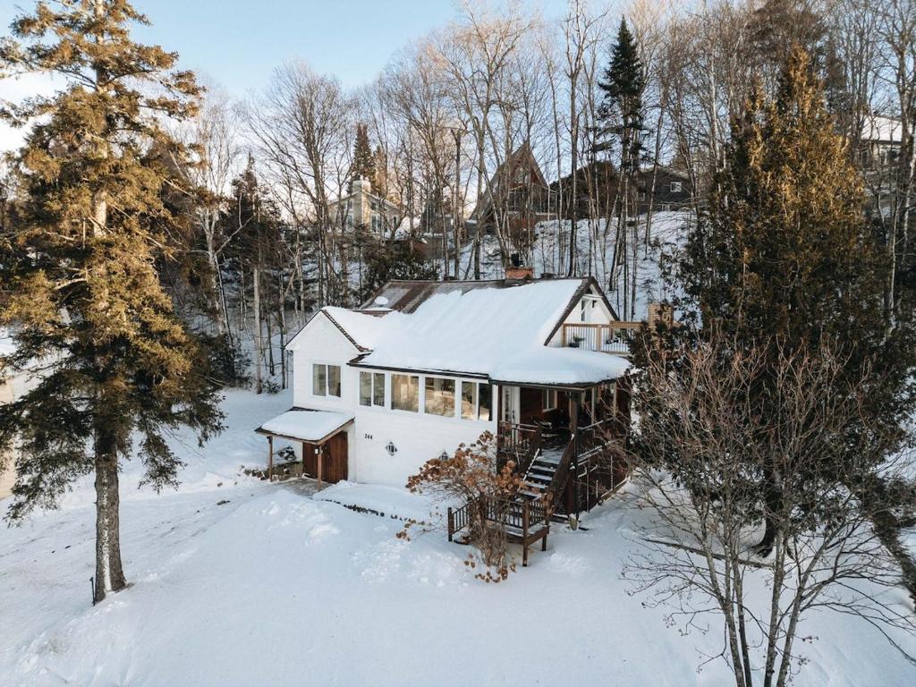 圣阿加瑟莫Luxury Lakefront Retreat Spa Beach Ski的一座白色的房子，上面覆盖着雪