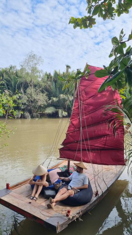 a group of people sitting on a boat on the water at Comfy Riverside Mekong homestay Ben Tre in Ấp Phú Hòa (3)