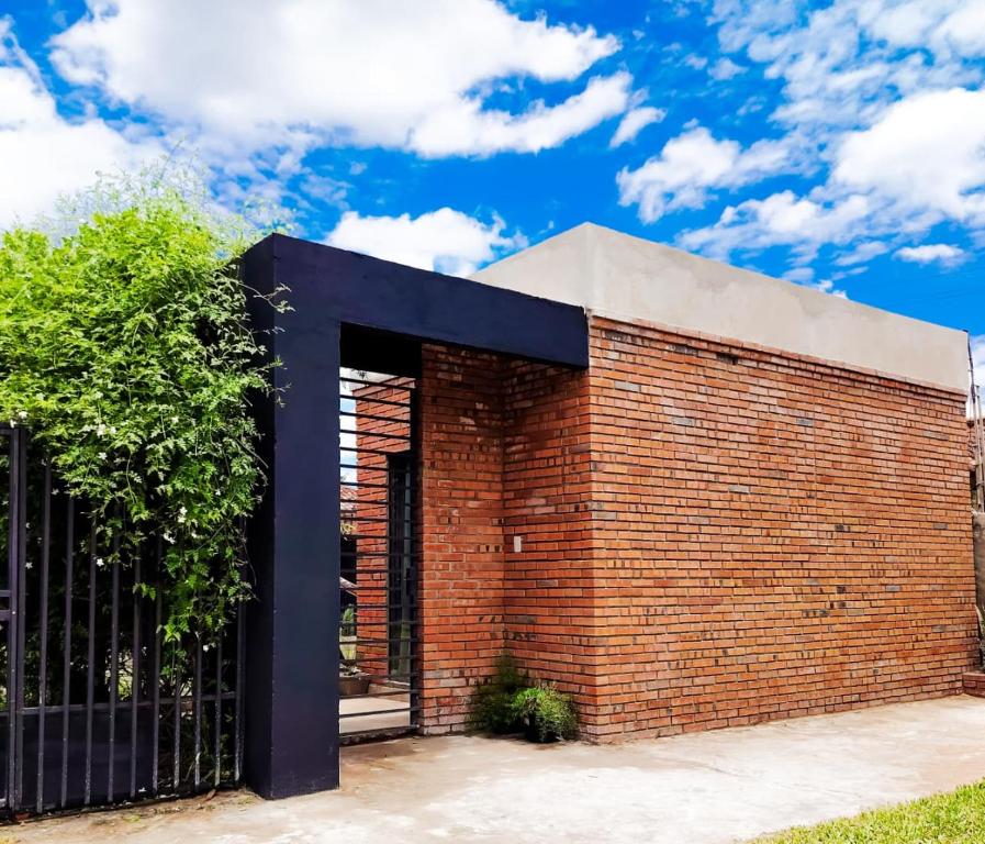 a red brick building with a black gate at Habitación standard - SKYHOME I in Luque