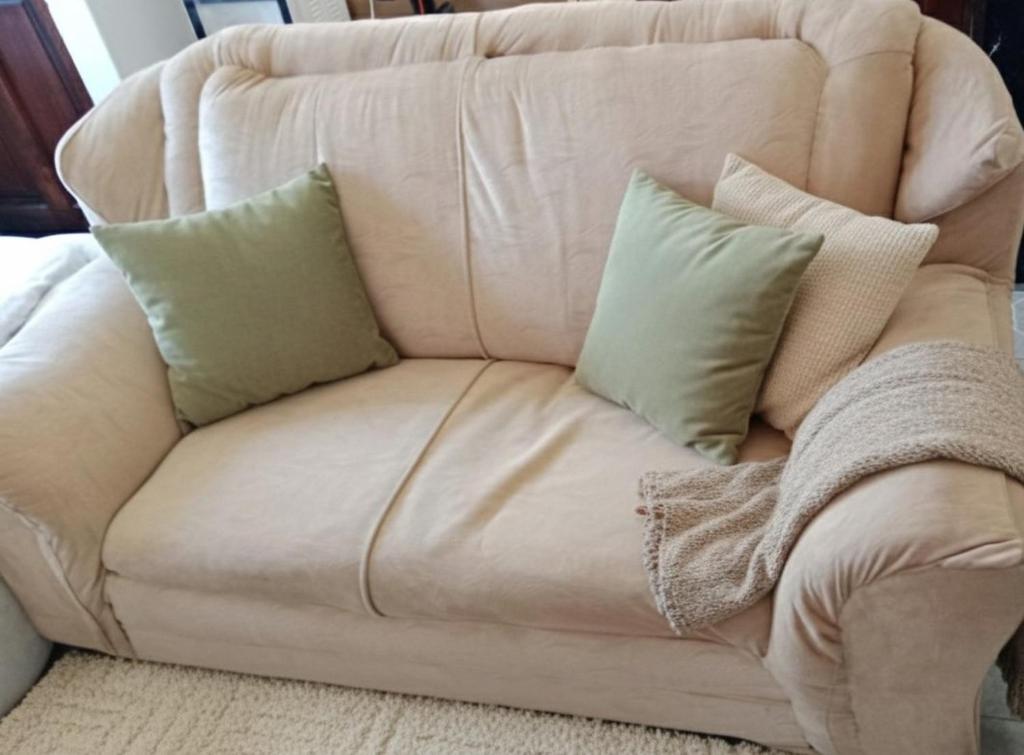 um sofá branco com algumas almofadas em Haven em Mombaça