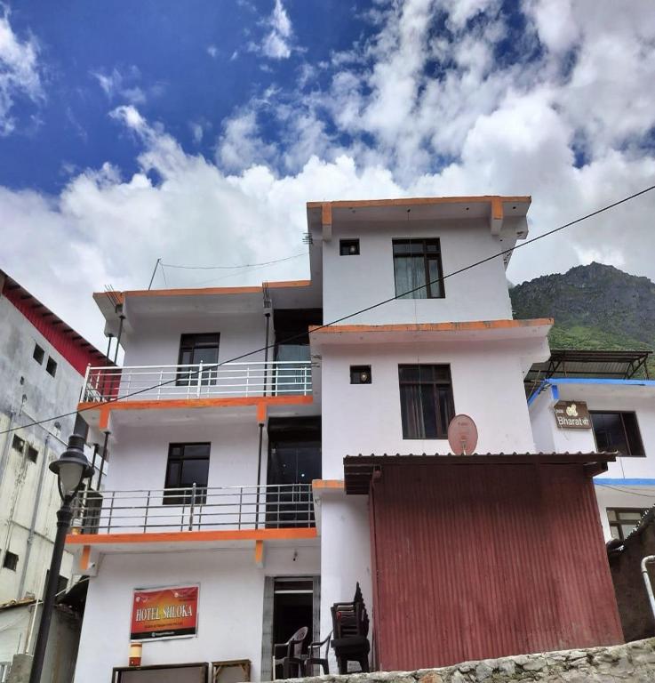 巴德里纳特The Shloka Badrinath By StayApart的一栋白色建筑，顶部有阳台