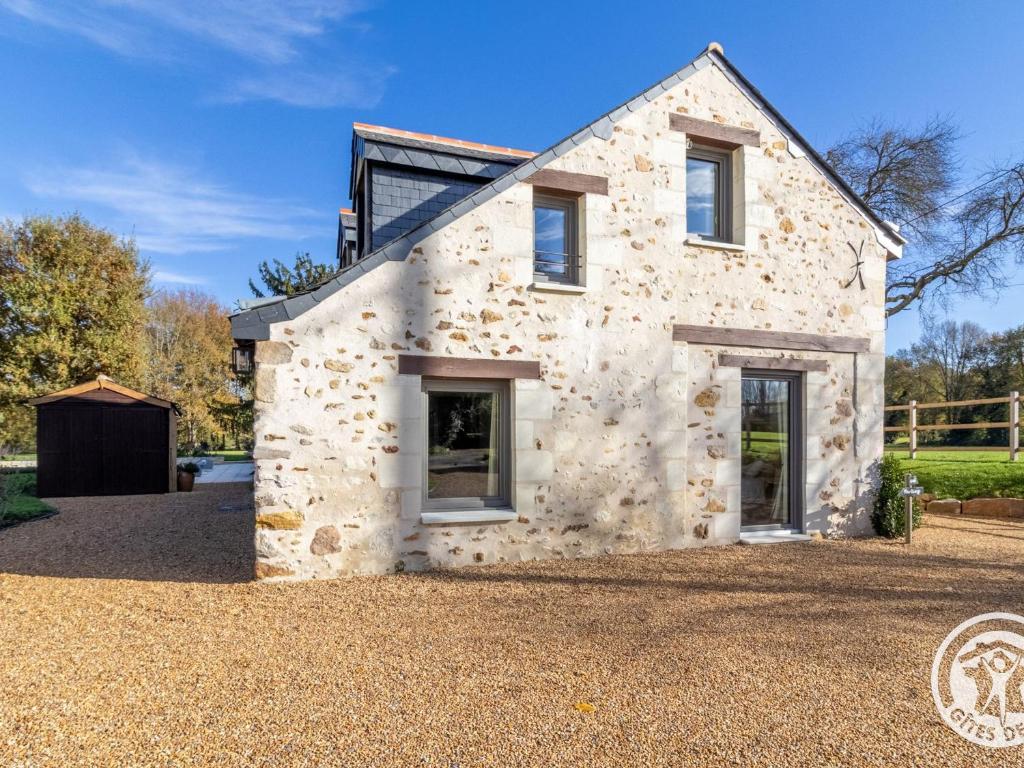 an old stone house on a gravel driveway at Gîte confortable à la campagne, 2 chambres, vue dégagée - FR-1-622-118 in Le Vieil-Baugé