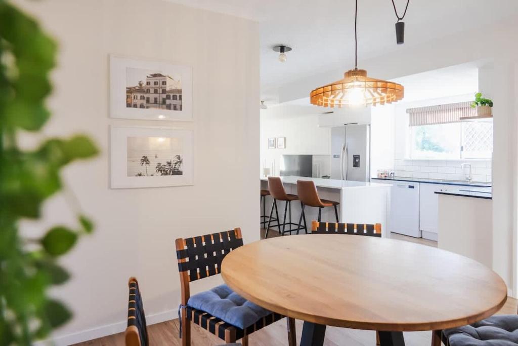 Una cocina y un comedor con mesa y sillas de madera. en Whitsunday Wanderluxe, en Cannonvale