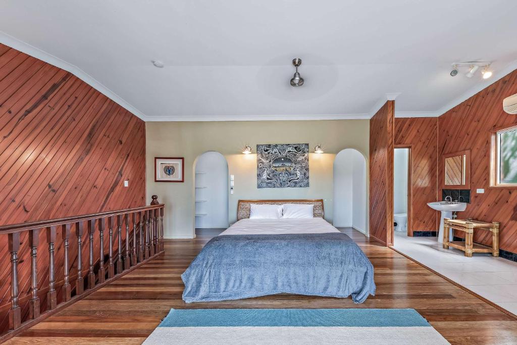a bedroom with a large bed and a sink at Treetop Paradise Retreat with Pool in Cannonvale
