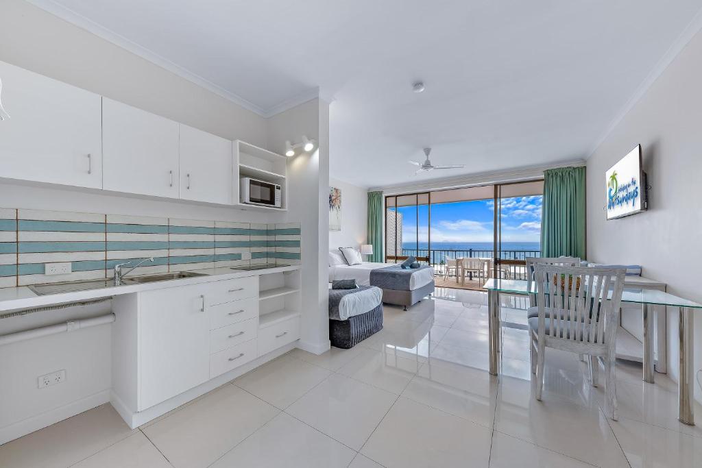 a kitchen and living room with a view of the ocean at Central Ocean View Studio 27a in Airlie Beach