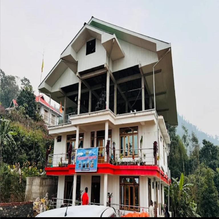a building with a man standing in front of it at Wanderlust Homestay By StayApart in Kalimpong