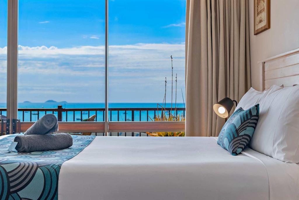 a bedroom with a bed with a view of the ocean at OCEAN VIEWS 10A in Airlie Beach