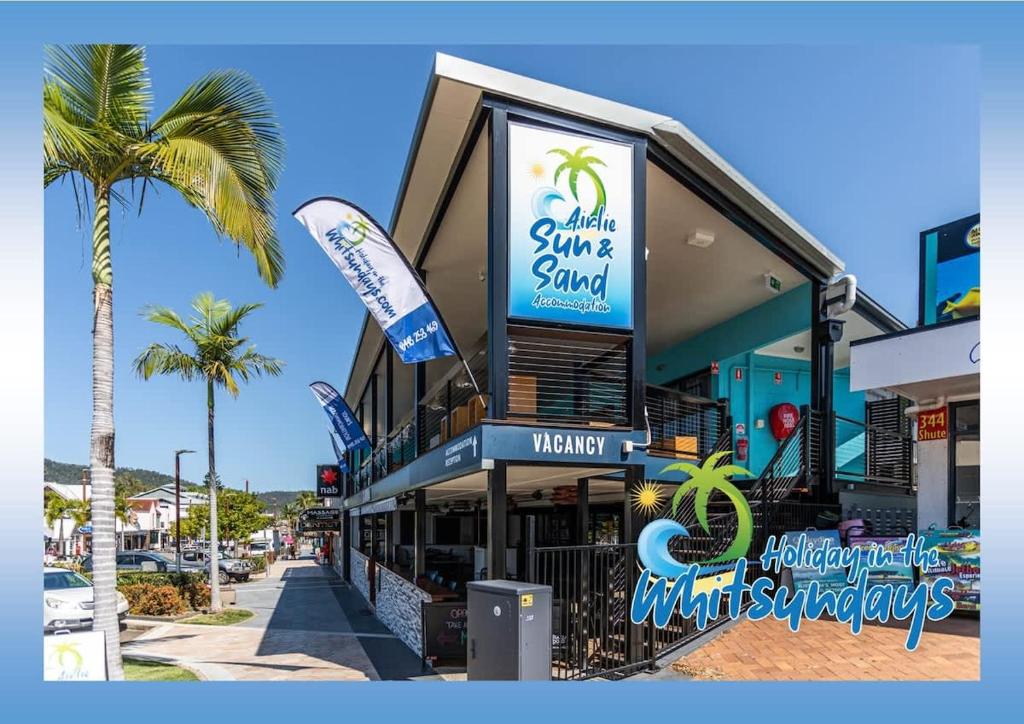 埃尔利海滩Airlie Sun & Sand Accommodation #3的棕榈树街道上的建筑