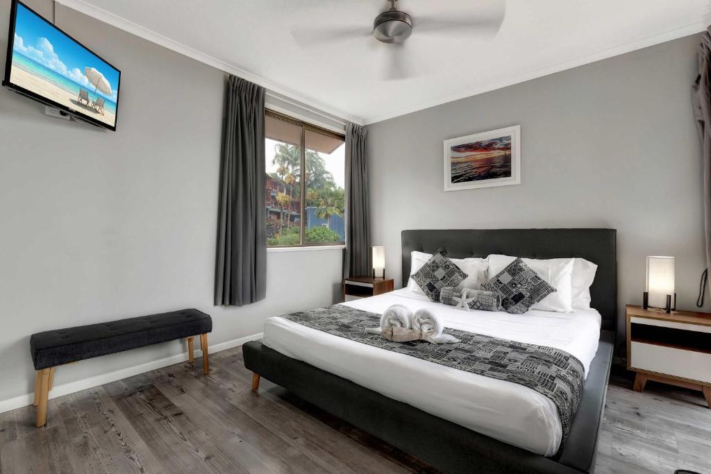 a bedroom with a large bed and a window at OCEAN VIEWS 16 pool & Spa Wi-FI in Airlie Beach