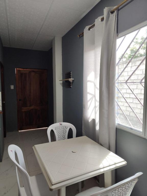 Un comedor con mesa y sillas y una ventana. en Departamento Elegante y acogedor hotel Económico, en La Libertad