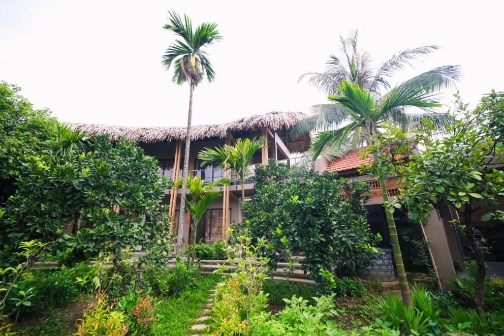 una casa con palmeras delante en Vanlong garden, en Kon Rung (1)