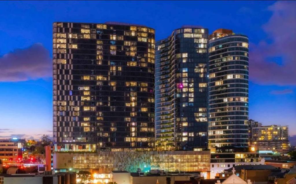 dos edificios altos en una ciudad por la noche en Luxury Apartments w Rooftop pool, en Brisbane