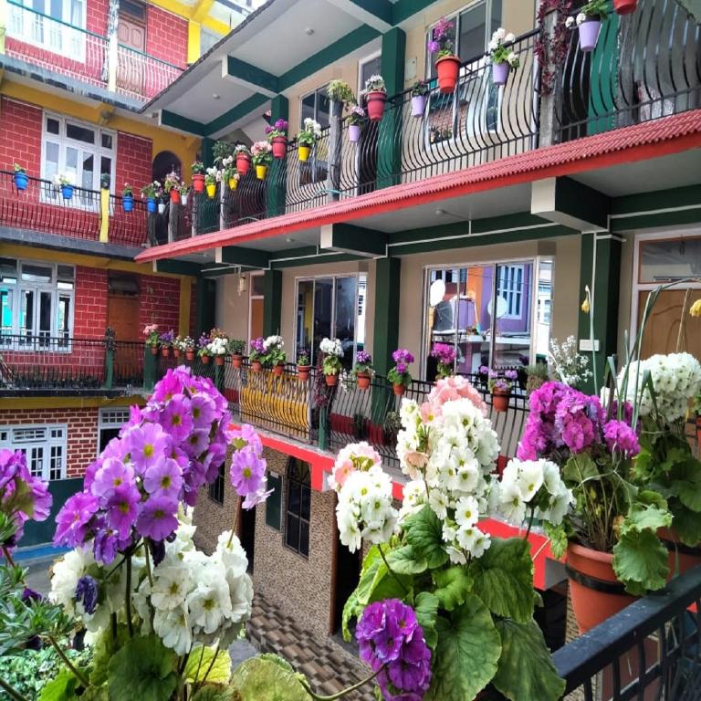 a building filled with lots of purple and white flowers at Neel Pahari Homestay By StayApart in Pedong