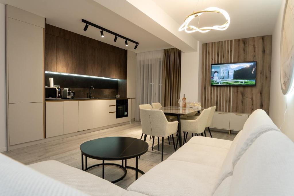a living room with a white couch and a table at GM Residence Deluxe 1&2 bedrooms in Suceava