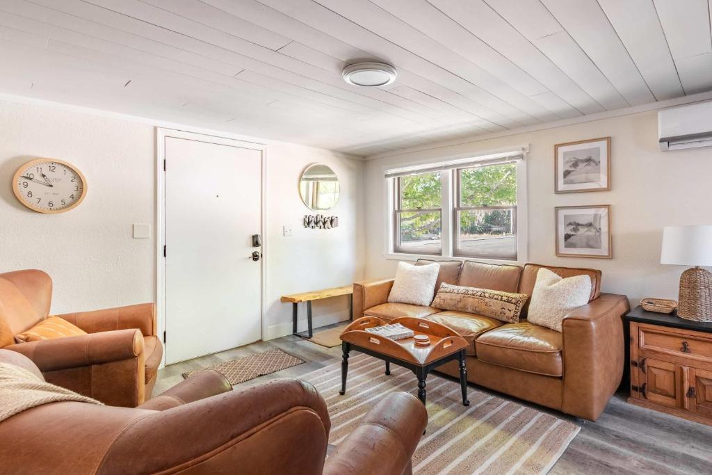 a living room with two couches and a table at Uptown 1 Bedroom Flat Near the Boise Train Depot in Boise