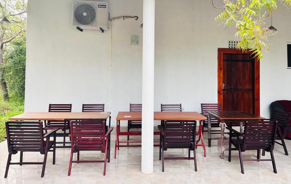 eine Gruppe von Tischen und Stühlen in einem Raum in der Unterkunft Neem safari lodge Yala in Tissamaharama