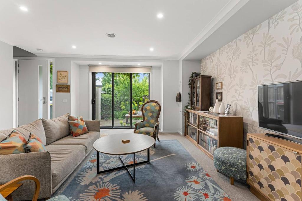 ein Wohnzimmer mit Sofa und Fernseher in der Unterkunft The Pattern House Ballarat Lakeside Creative Haven in Eureka