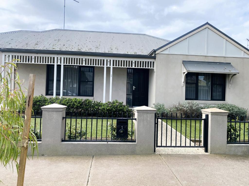 ein weißes Haus mit einem Tor davor in der Unterkunft BROWNBILL STREET GEELONG a 2 Bedroom Unit located in the heart of East Geelong in Geelong
