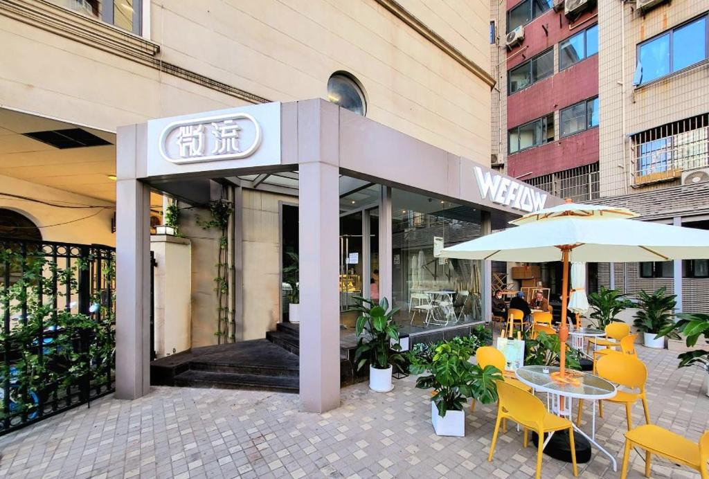 a restaurant with a table and chairs and an umbrella at WeFlow Youth Hostel - Shanghai People's Square Jing'an Joy City in Shanghai