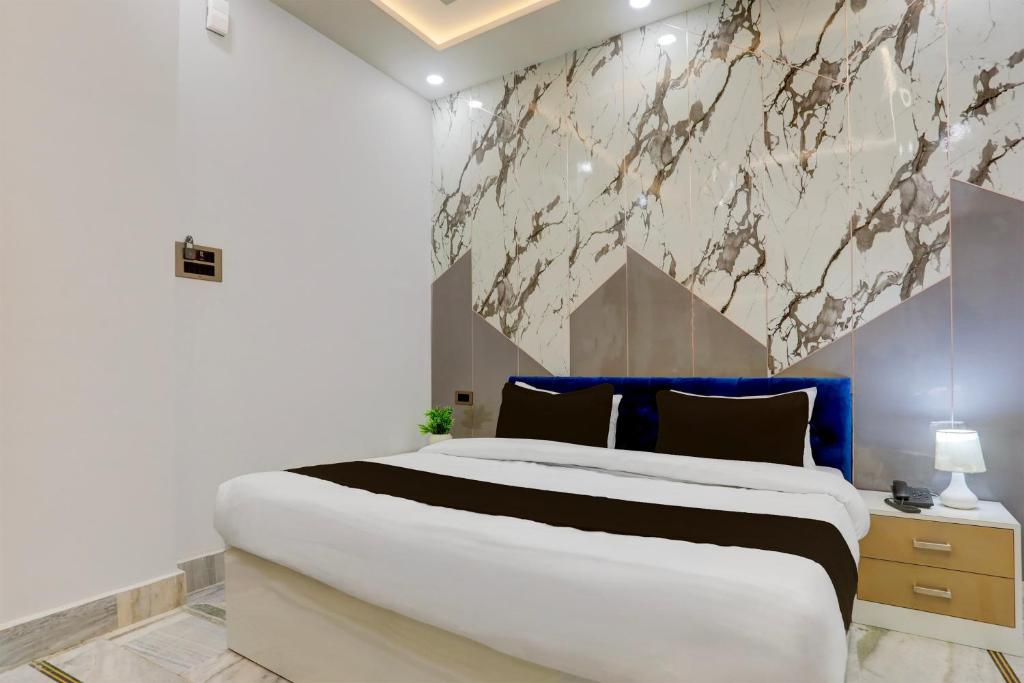 a bedroom with a large bed and a marble wall at Super Townhouse Vishwanath Temple Varanasi in Varanasi