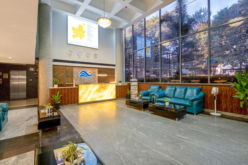 - un hall doté d'un mobilier bleu et de grandes fenêtres dans l'établissement Sunrise A Boutique Hotel, Kondapur - Gachibowli, à Kondapur
