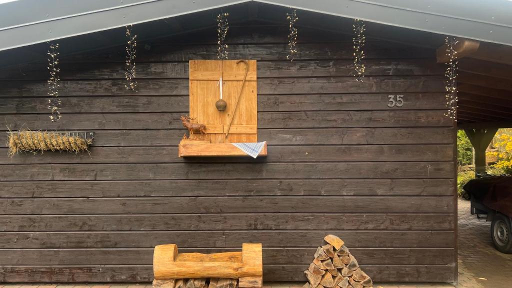 a wooden house with a cat on the side of it at Die Waldstube in Bromskirchen