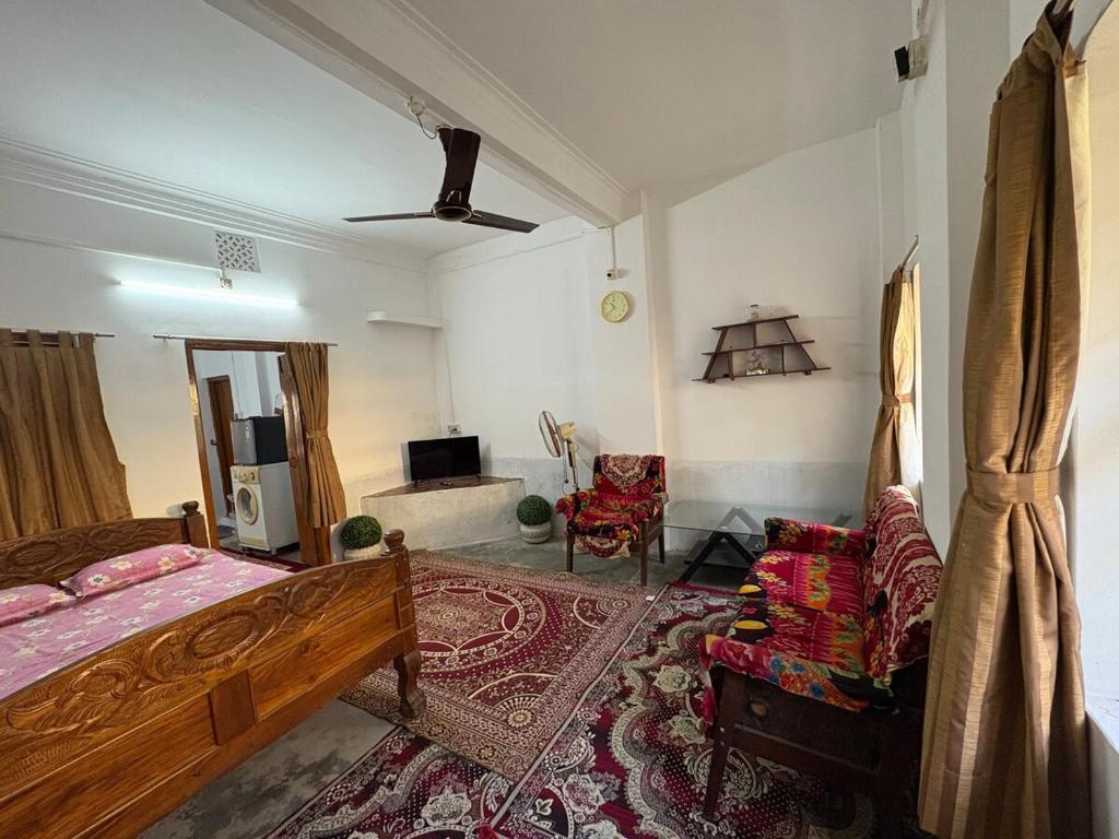 a bedroom with a bed and a living room at The Indoor Retreat in Siliguri