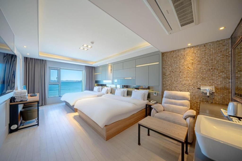 a hotel room with a bed and a bath tub at Pohang Hotel View in Pohang