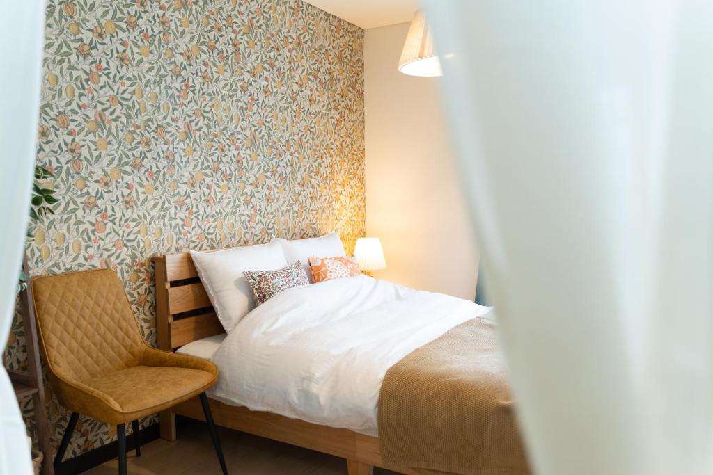 a bedroom with a bed and a chair at 栗林公園の畔 in Takamatsu