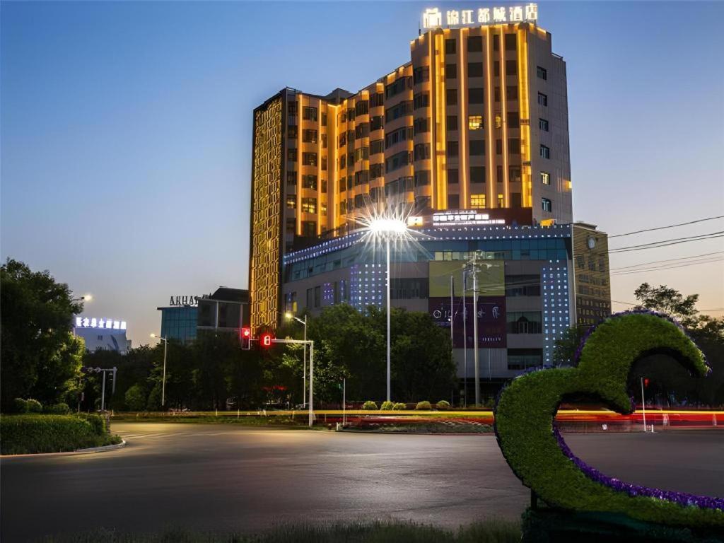 un grand bâtiment avec un serpent vert devant lui dans l'établissement Metropolo Hotel Yining Development Zone Hanma Building, à Yining Airport