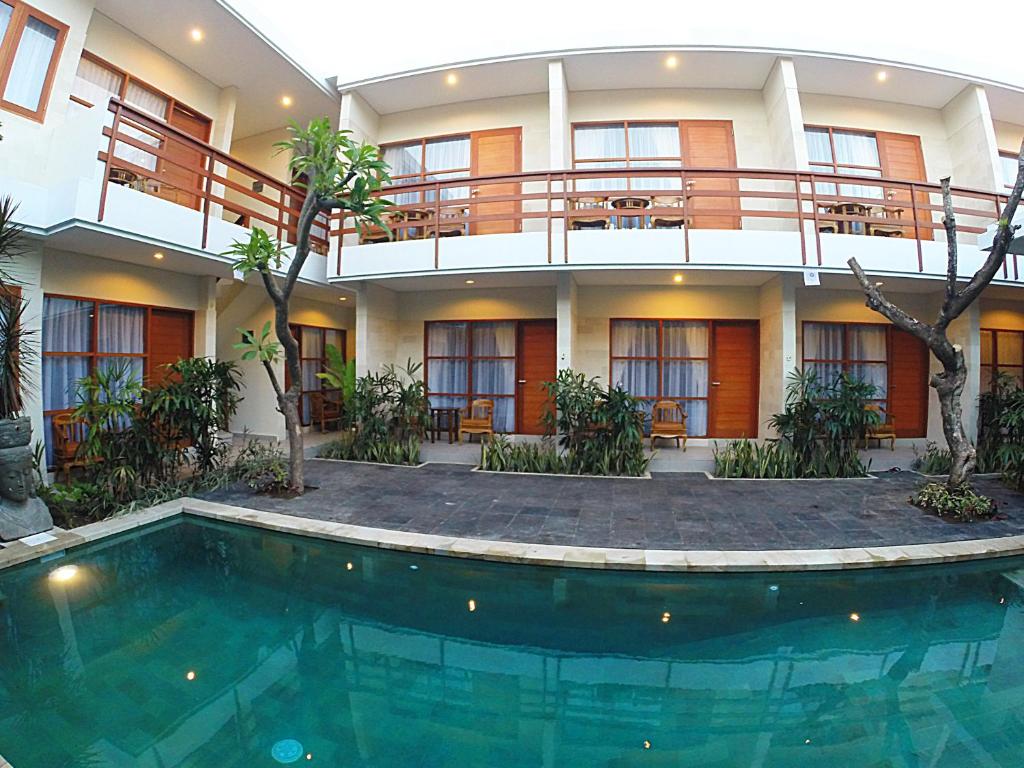 a hotel with a swimming pool in front of a building at Asoka Hotel & Suite in Sanur