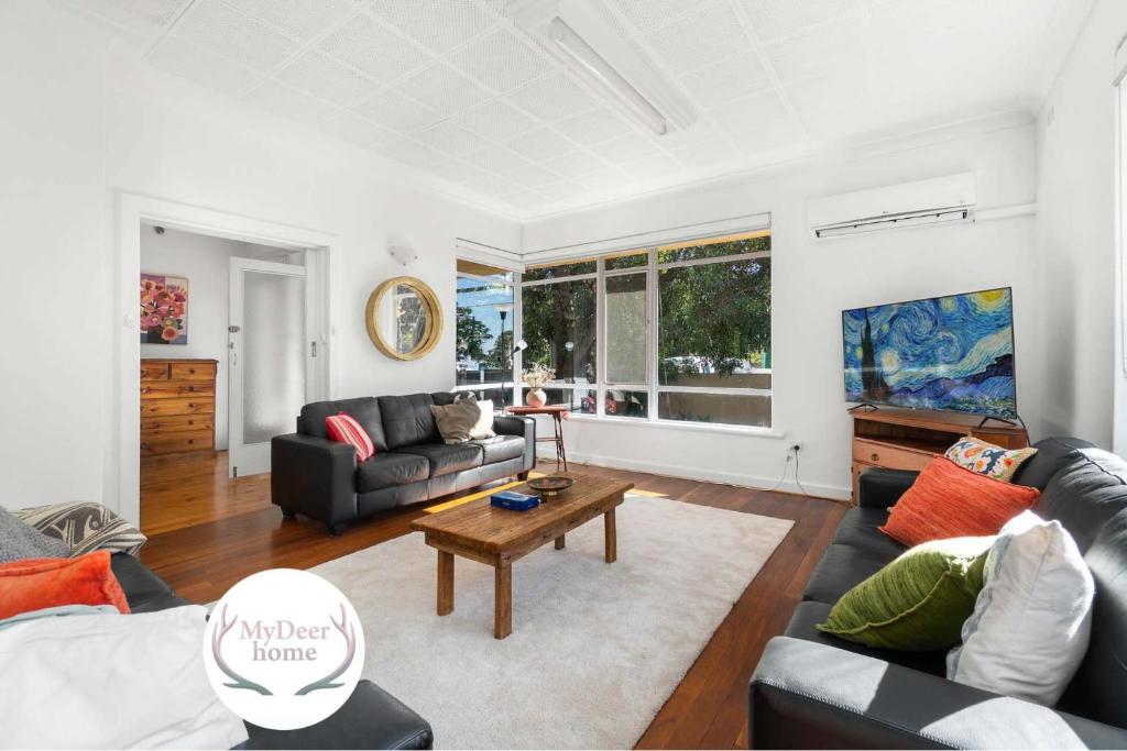 a living room with a couch and a table at The Spacious & Elegant Vacation Haven - Glenside in Glenunga