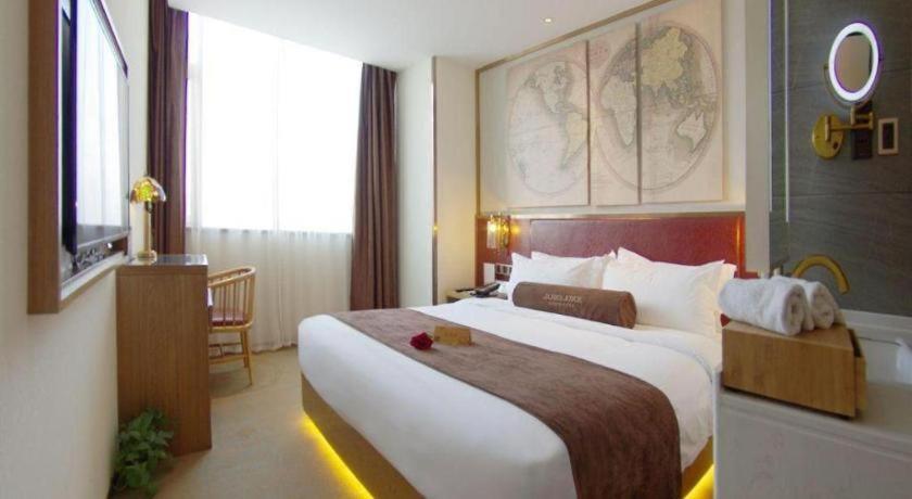 une chambre d'hôtel avec un grand lit et une fenêtre dans l'établissement James Joyce Coffetel Beijing Yizhuang Rongjing East Street Subway Station, à Pékin