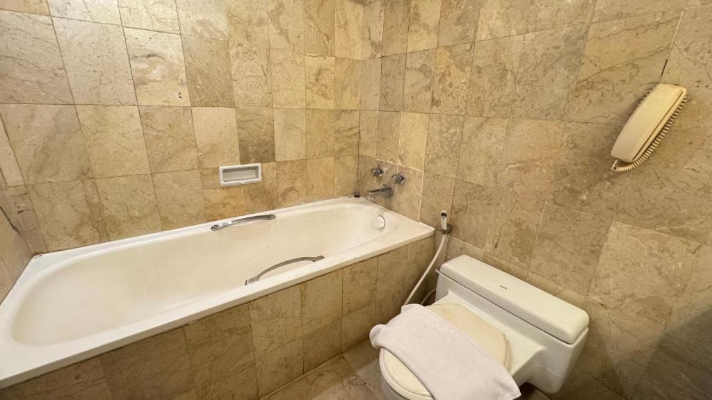 ein Badezimmer mit Badewanne, Toilette und Waschbecken in der Unterkunft HERITAGE by Grand Sahid Jaya in Jakarta