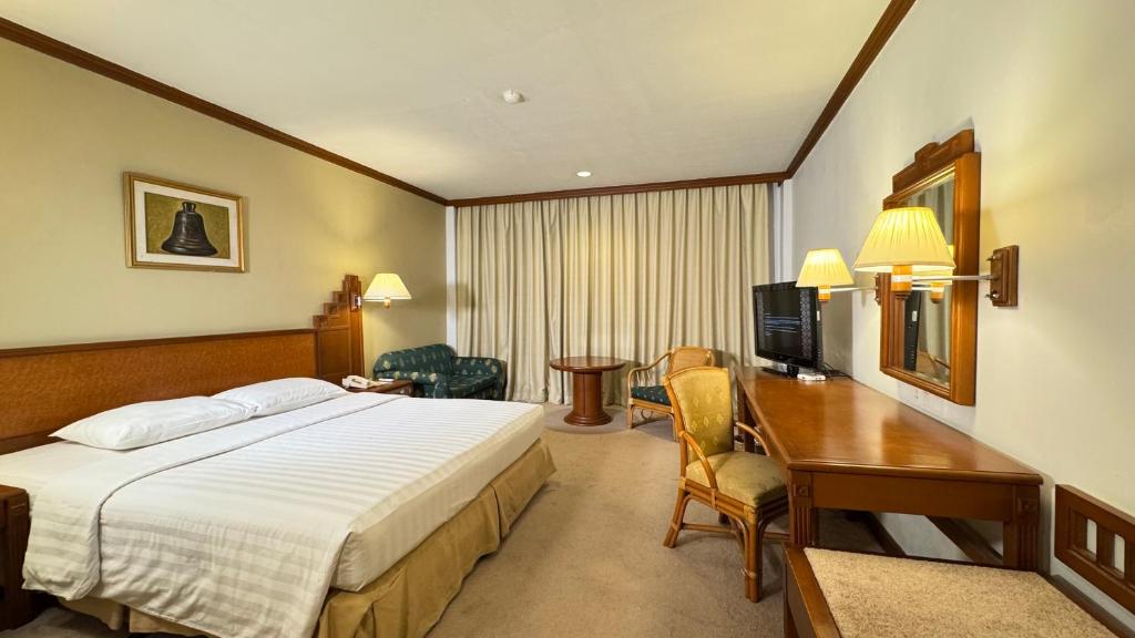 雅加达HERITAGE by Grand Sahid Jaya的一间配有床和书桌的酒店房间