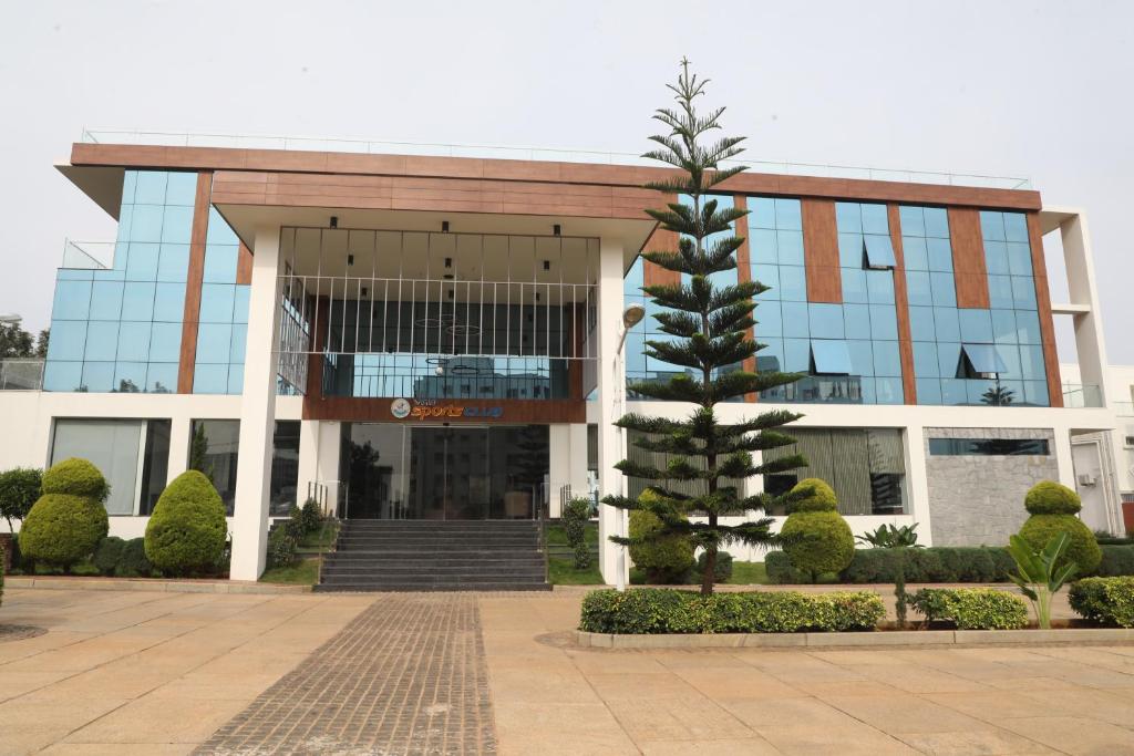un edificio con un árbol delante en INSPIRE Hotel, en Kammasandra