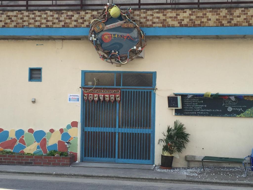 un edificio con una puerta azul y un cartel en él en Guest House & Cafe Ohana, en Imabari