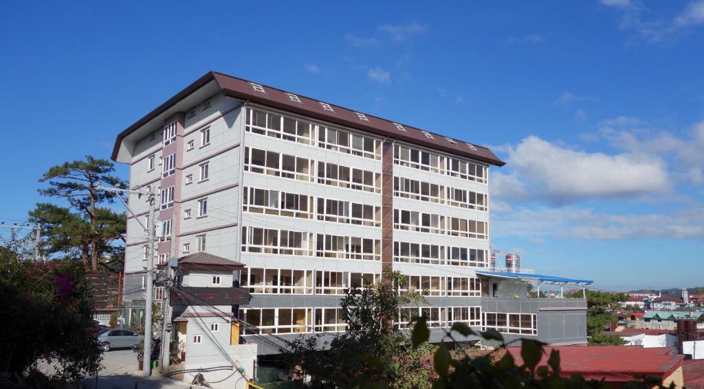 a tall white building with a red roof at Bang-kito City Central Suites in Baguio