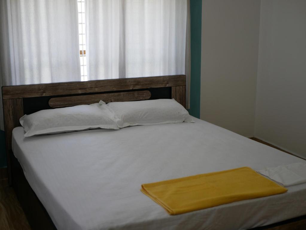 ein Bett mit einem hölzernen Kopfteil und einem gelben Tablett darauf in der Unterkunft PEARL SPOT Munroe Serviced Villa in Munroe Island