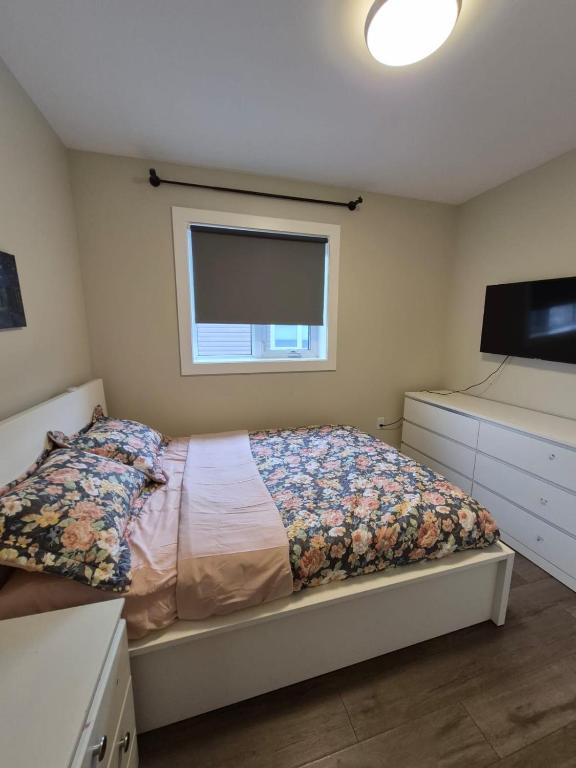 een slaapkamer met een bed en een flatscreen-tv bij Comfort Tenacity in Yellowknife
